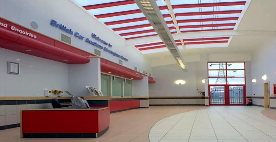 Interior view of British Car Auctions Birmingham auction hall showing ceiling grid and tile finish