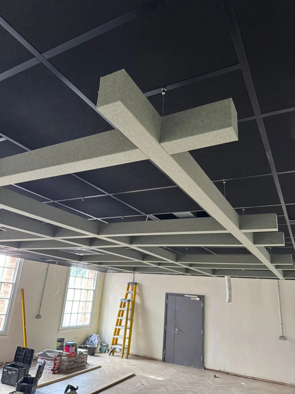 White suspended acoustic baffles being coordinated beneath the black Jubilee Campus ceiling