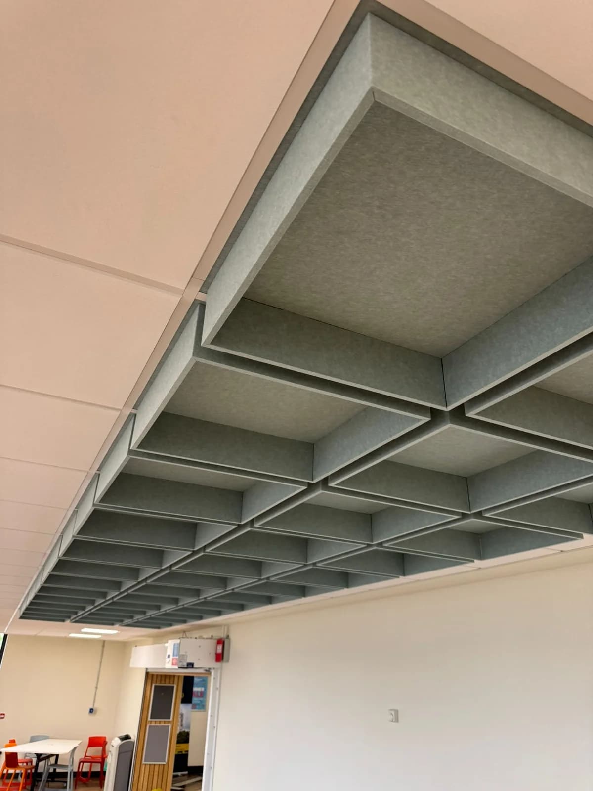Close view of suspended acoustic baffle frames below white ceiling tiles at Jubilee Campus