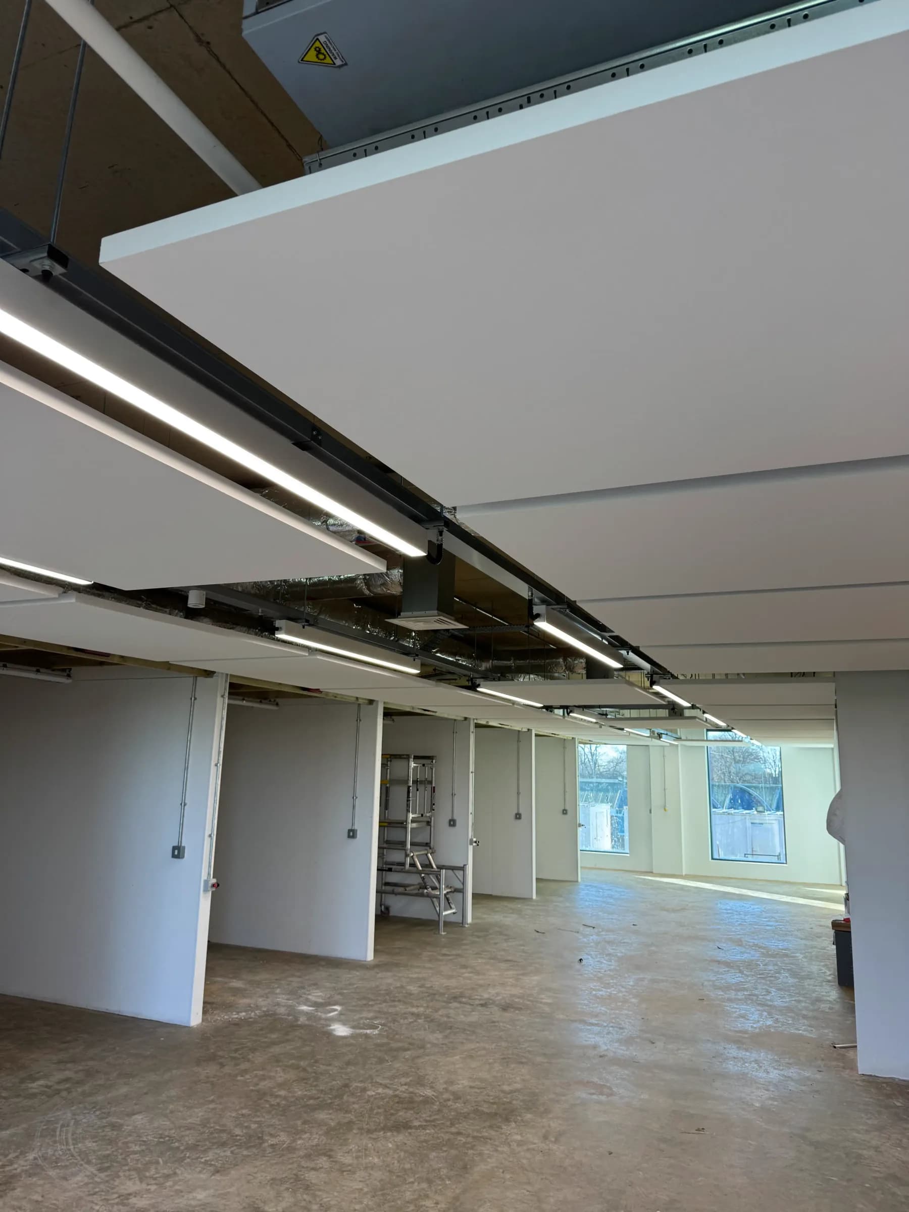 Ceiling acoustic treatment at Peterborough College showing suspended raft installation and spatial coverage