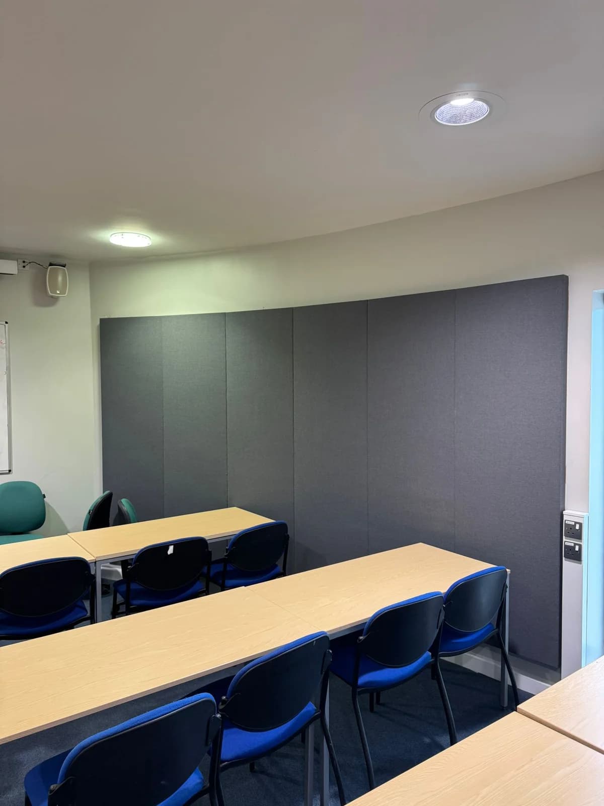 Completed acoustic wall panels behind teaching tables at Portland Building