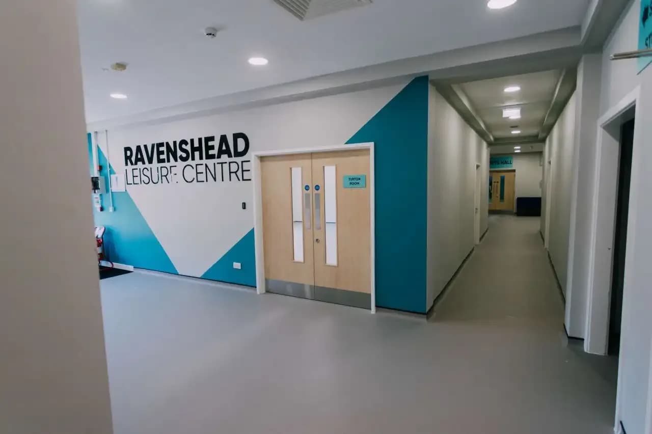 Wide view of Ravenshead Leisure Centre sports hall with completed acoustic treatment on walls and ceiling