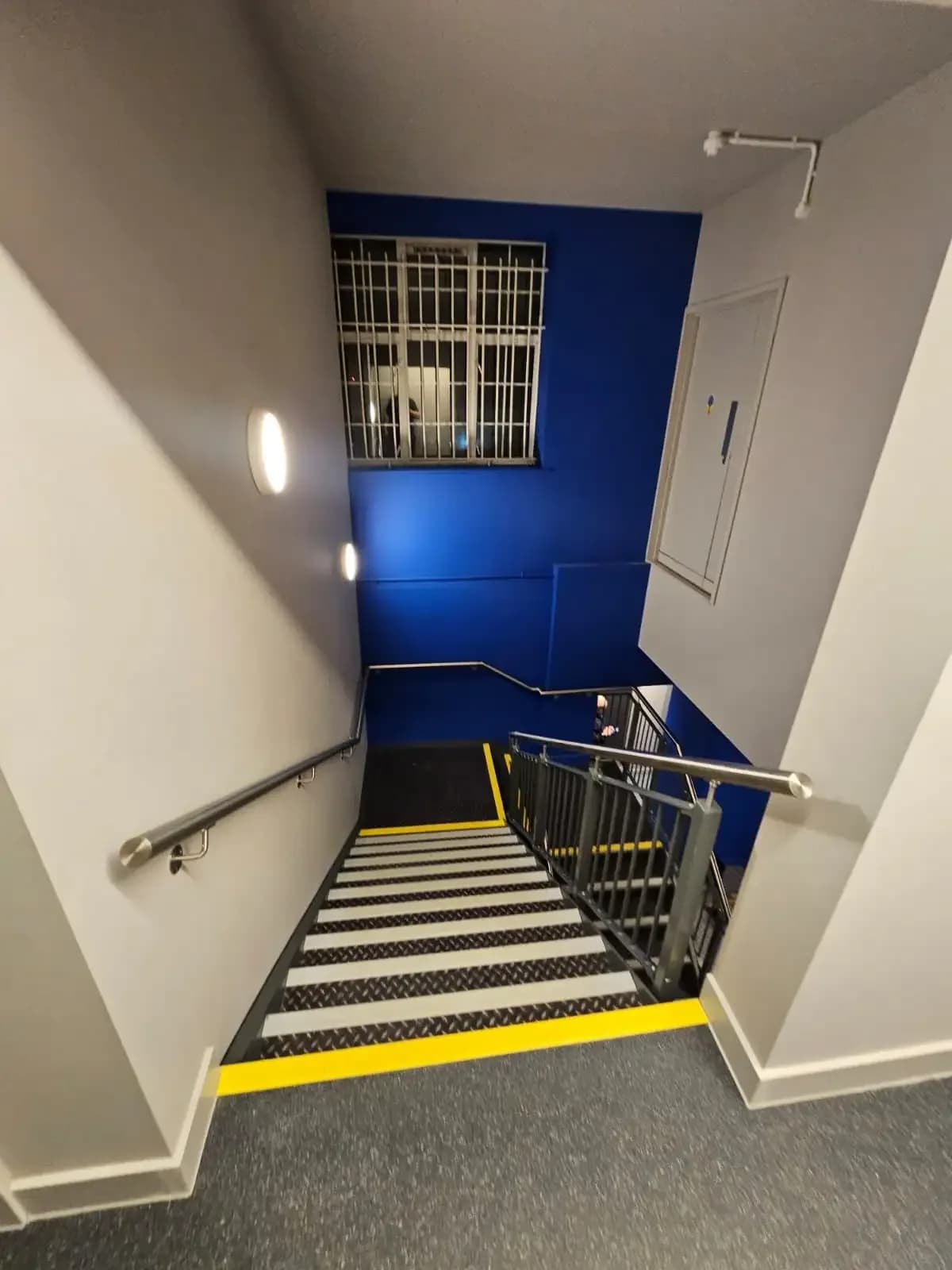 Finished dry-lined stairwell walls installed by Eastledge at The Gym Group Hendon bank-to-gym conversion in London.