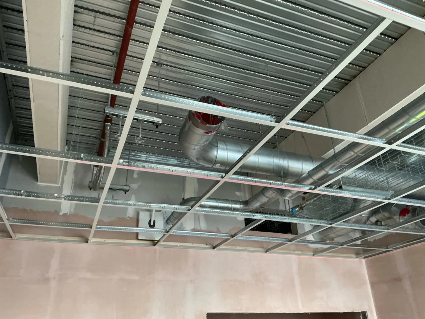 Exposed T-bar grid ceiling installation at Burleyfield School showing service integration